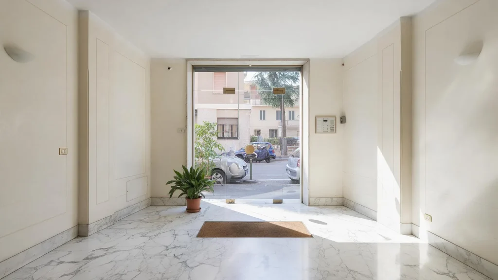 Ingresso di un condominio appena ristrutturato con pareti bianche e pavimento in marmo